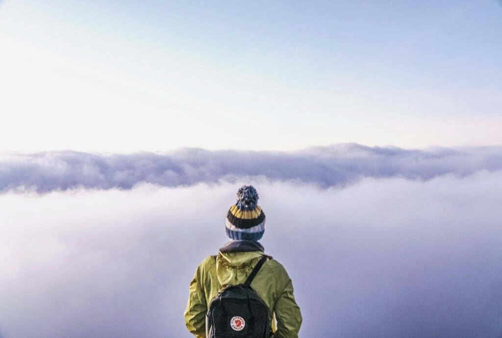 person looking thru sea of clouds